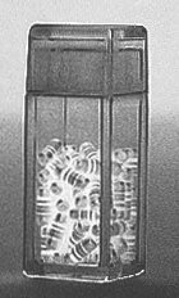 The image shows a transparent container filled with many small, spiral-shaped objects. The container is rectangular in shape and has a lid.