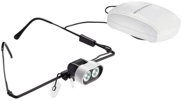 Das Bild zeigt eine spezielle Brille mit zwei kleinen, hellen LED-Lichtern vorne. An einem Kabel ist ein weißes Steuergerät befestigt. Die Brille hat schwarze Bügel.