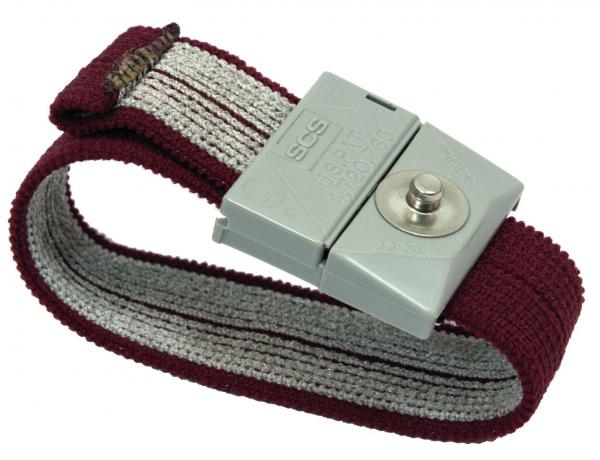 Das Bild zeigt ein elastisches Armband aus rotem und grauem Gewebe. In der Mitte ist eine graue Schnalle mit einem Druckknopf, die das Armband verschließt.