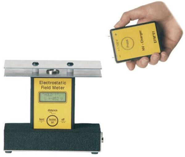 The image shows an electrostatic measuring device, consisting of a large, stable base unit with a display and a handheld sensor. Both are designed in yellow and black.