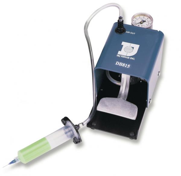 Das Bild zeigt ein medizinisches Gerät: eine kompakte, graue Pumpe mit einem Manometer und einem transparenten Schlauch, der zu einer Spritze führt. Die Spritze hat einen grünen Kolben.
