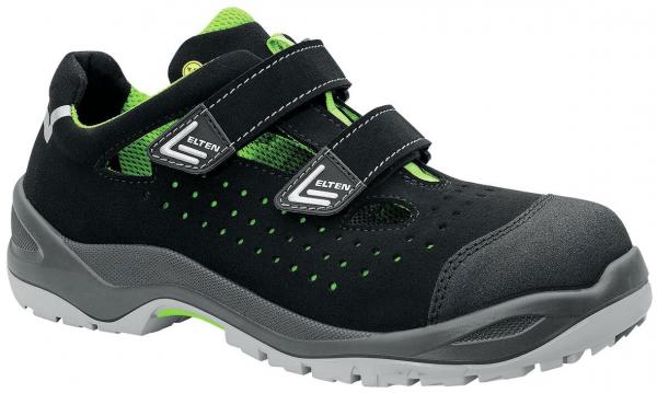 It is a black shoe with green accents. It has two velcro straps and a breathable upper with small holes. The sole is grayish and sturdy.