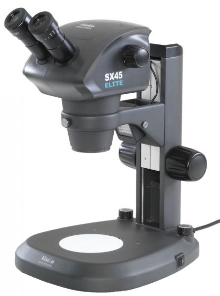 The image shows a microscope with two objectives and a stable base. It has a gray body and various controls on the side to adjust the settings.