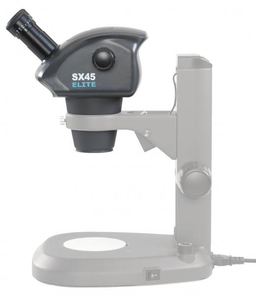 The image displays a microscope in black and gray. The upper part features a round lens and an eyepiece, while the base is flat and stable. A cable connects the microscope to a power source.