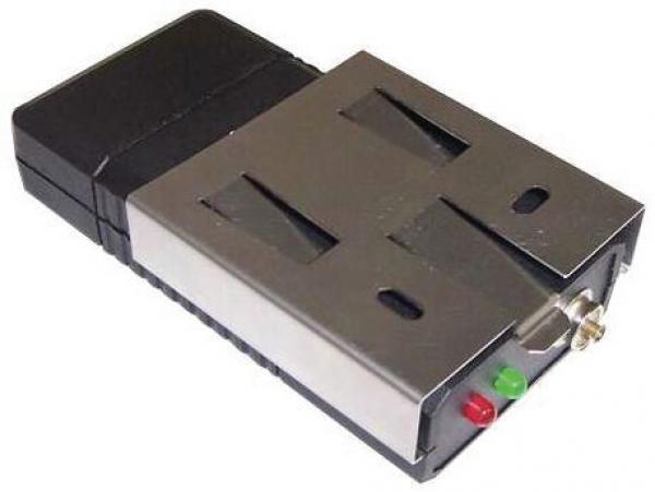 Das Bild zeigt ein elektronisches Gerät mit einem schwarzen Kunststoffgehäuse und einer silbernen Metallfront. Auf der Vorderseite befinden sich zwei Schlitze und zwei Lichtanzeigen: eine grüne und eine rote.