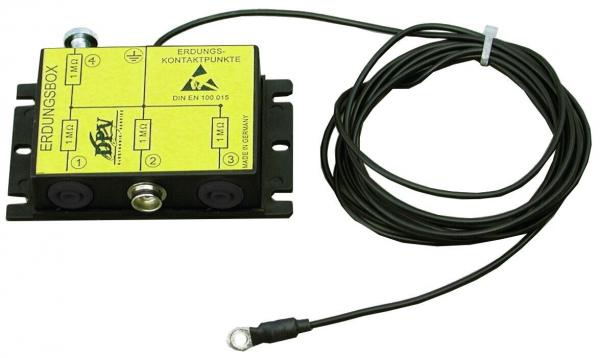 The image shows a yellow grounding box, rectangular with two sockets and a terminal block. A black cable leads away from the box to make a connection.