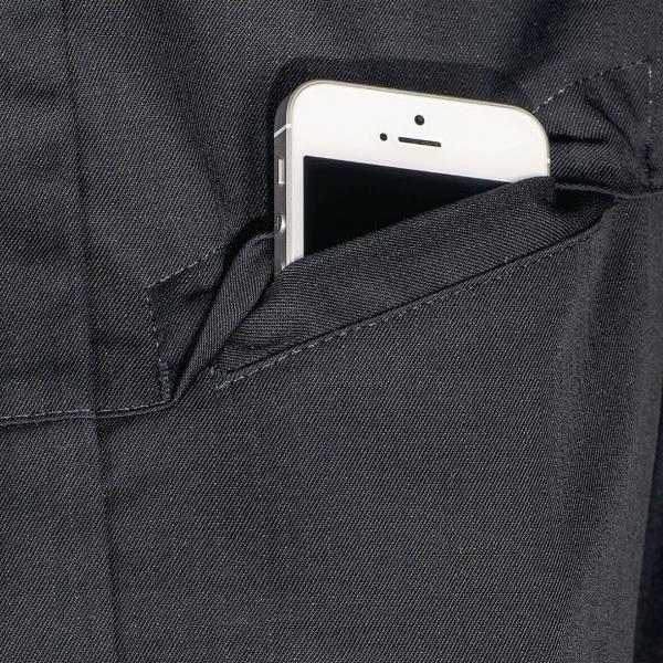 In dem Bild ist ein Smartphone in einer dunklen Hosentasche zu sehen. Nur der obere Teil des Telefons ragt heraus, der Bildschirm ist schwarz. Die Tasche hat eine klare, schlichte Naht.