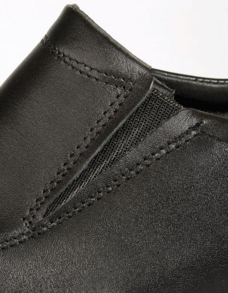 Das Bild zeigt einen Teil eines schwarzen Schuhs aus Leder. Der Schuh hat eine elastische Einsätze und feine Nähte, die ihm ein elegantes Aussehen verleihen.
