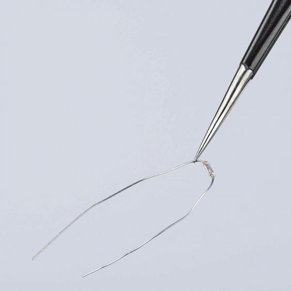The image shows a fine, curved needle held by tweezers. The needle has a small opening at one end and is placed against a light background.