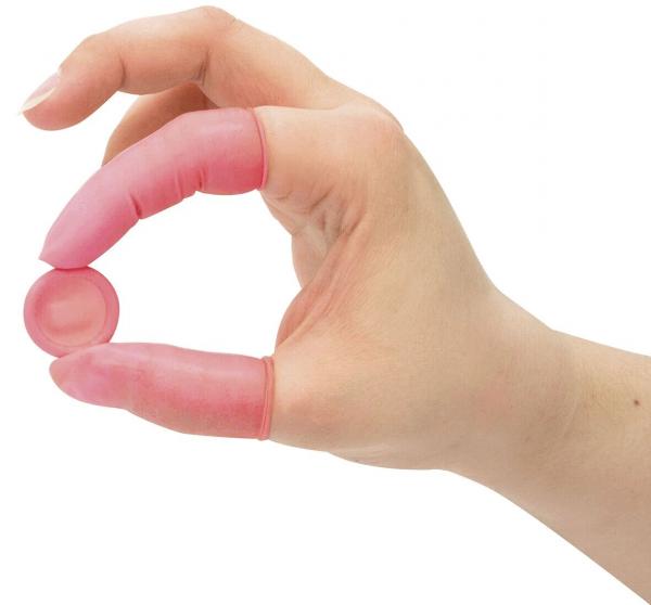 A hand with long, pink finger cots holds a small round, also pink disc between the thumb and forefinger. The hand is slightly open.