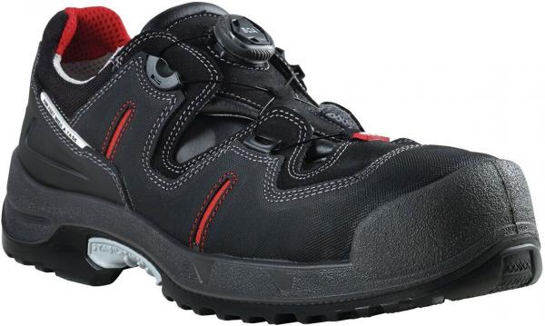 Der Schuh ist schwarz mit roten Akzenten. Er hat eine robuste, gezahnte Sohle und eine verstärkte Zehenkappe. Das Schnellschnürsystem sorgt für einfachen Halt und Komfort.