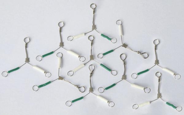 The image shows several wire-like objects arranged in a triple Y-shape. Each Y-shape has a gray middle part and white and green end pieces.