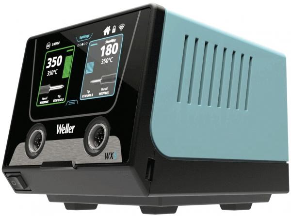 Das Bild zeigt ein technisches Gerät mit einem modernen Design. Es hat eine schwarze Front mit zwei analogen Anzeigen und Tasten. Die Seiten sind in einem hellen Blau gehalten, mit Belüftungsöffnungen.