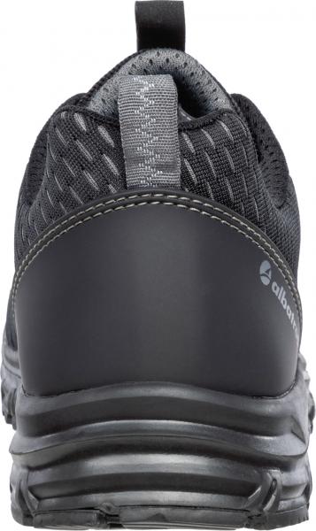 The shoe is a sporty, black sneaker with a breathable mesh surface and a sturdy rubber sole. The heel is reinforced and features a slightly raised pattern.