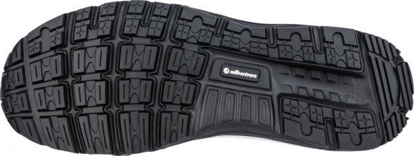 The image shows the sole of a sports shoe. It is black with a complex pattern of grooves and knobs that provide better grip. A logo is visible in the center.