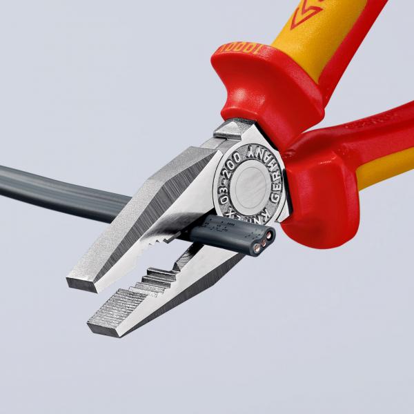 The image shows a pair of pliers with red and yellow handles. The pliers are holding a thin wire, which is partially insulated. The edges are sharp and serrated, ideal for cutting or gripping.