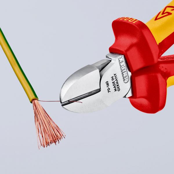 An isolated green wire is being worked on with pliers. The pliers have a red and yellow handle. Individual copper wires are visible at the end of the wire.