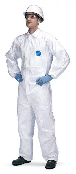 A person stands upright in a white protective suit, with blue gloves and a white helmet. They have their hands on their hips and are looking forward.