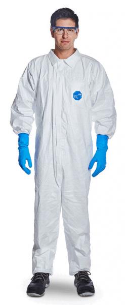 A person is wearing a white protective suit with long sleeves, blue latex gloves, and safety goggles. The background is neutral and dimmed.