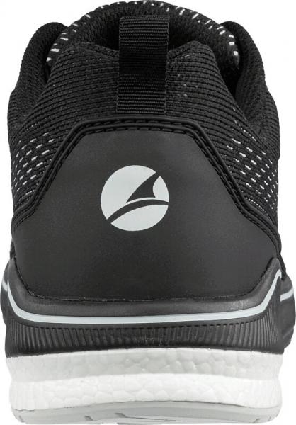 The image shows the rear view of a black sports shoe with a gray logo. The shoe has a textured surface and a white sole. There is a small loop at the top.