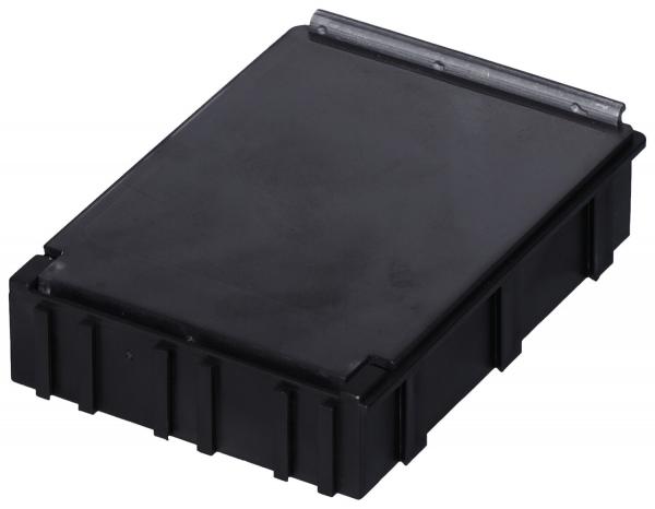 Das Bild zeigt eine rechteckige, flache schwarze Box mit einem glatten Deckel und einer kleinen Metallschnalle. Die Seiten sind leicht erhöht und haben ein gezacktes Muster.