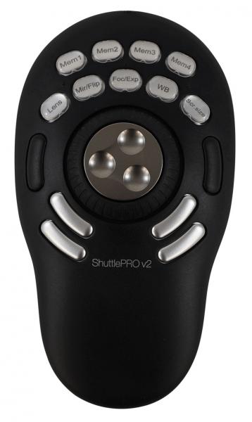 The image displays a black control unit with an oval shape. In the center, there are three buttons arranged in a circle. Above, several labeled buttons are scattered.