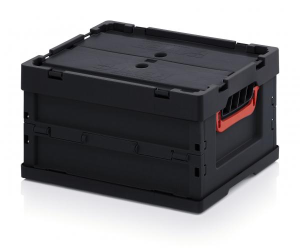 Auf dem Bild ist eine schwarze Kunststoffbox zu sehen. Sie hat einen rechteckigen Korpus mit einem flachen Deckel. An der Seite befindet sich ein roter Griff für den Transport.