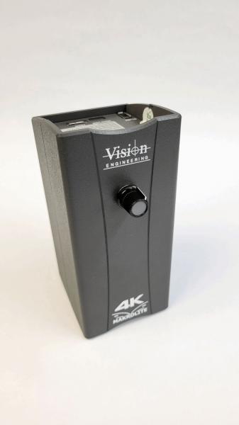 Das Bild zeigt ein scharfkantiges, schwarzes Gerät mit einer vertikalen Form. Es hat einen Drehknopf in der Mitte und eine Kennzeichnung für ?4K? an der Unterseite. Die Oberseite hat Anschlussmöglichkeiten.