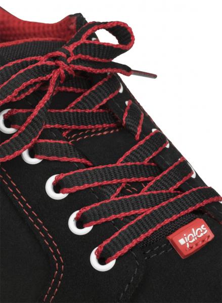 Das Bild zeigt einen schwarzen Schuh mit roten Schnürsenkeln. Die Ösen sind weiß und der Schuh hat eine rote Markenlabel. Die Naht ist ebenfalls rot und sorgt für einen attraktiven Kontrast.