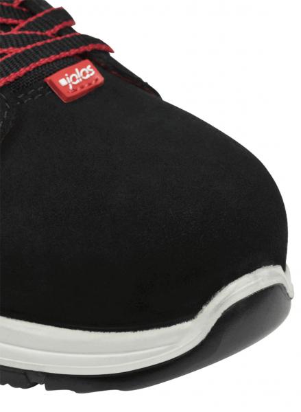 Das Bild zeigt die Vorderansicht eines schwarzen Schuhs mit rotem Logo. Der Schuh hat eine robuste Konstruktion und eine helle, rutschfeste Sohle. Schnürsenkel sind sichtbar.