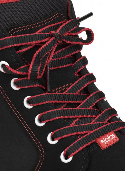 Das Bild zeigt einen schwarzen Schuh mit roten Schnürsenkeln. Die Schnürsenkel sind aufwendig gebunden und verlaufen durch weiße Ösen. Ein kleiner roter Aufnäher ist sichtbar.