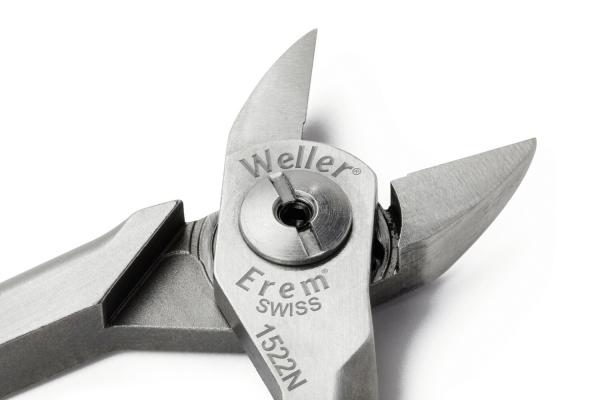 Das Bild zeigt eine Zange aus Metall mit einer scharfen Spitze und einem glänzenden Finish. Die Zange hat eine präzise, kompakte Form und trägt eine Markenbezeichnung.