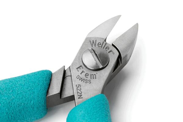The image shows a pair of pliers with two sharp blades that taper to a point. The handle is blue and has a non-slip surface. Brand and model symbols are embossed on the pliers.