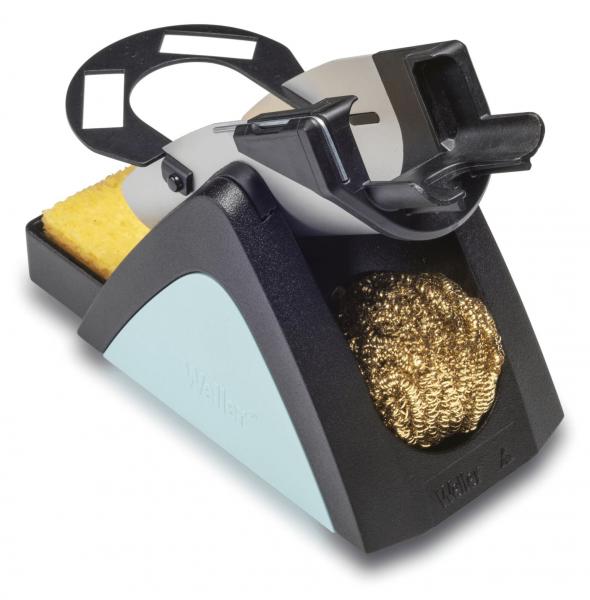 The image shows a kitchen gadget equipped with a sponge and a metal brush. It has a black base and a gray top, which is ergonomically shaped.