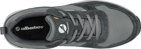 The shoe is gray and features a combination of mesh and suede materials. It has a flat sole and laces. The lining is black and the brand is visible.
