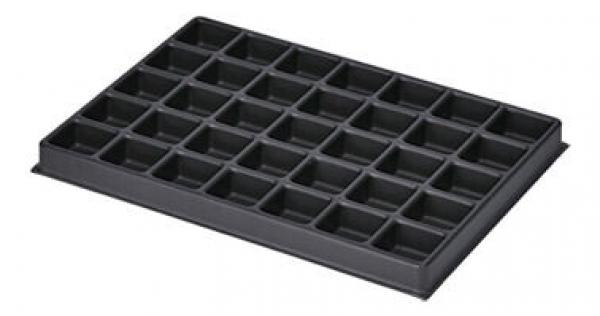 Das Bild zeigt eine schwarze Kunststoffform mit 36 kleinen quadratischen Fächern. Die Fächer sind gleichmäßig angeordnet und dienen wahrscheinlich zur Aufbewahrung oder zum Formen von Materialien.