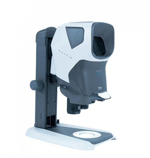 The image shows a medical device that appears as a compact, gray and white box on a stable base. It has an opening at the front and is designed to measure eye movements.