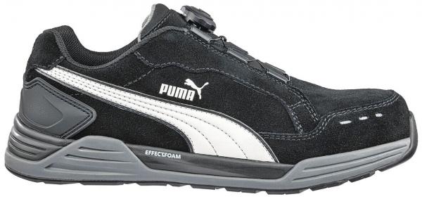 The shoe is black with a white, curved line on the side. It has a sturdy sole and a sporty design, ideal for leisure and activity.