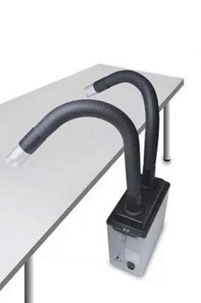 The image depicts a device with two long, flexible hoses that bend upwards. It is placed on a table and has a black, square base with controls on the side.