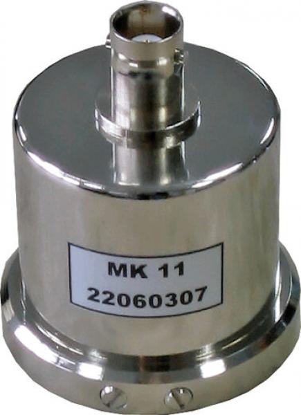 Das Bild zeigt ein metallisches, zylindrisches Bauteil mit einer runden Basis und einem Anschluss oben. Es hat eine glatte Oberfläche und trägt ein Etikett mit der Aufschrift "MK 11" und einer Nummer.