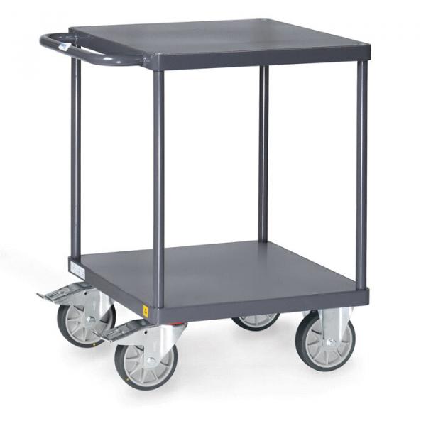 The cart has a square, sturdy table with two shelves. It is made of gray metal and stands on four large, swivel wheels. A side handlebar makes it easier to push.