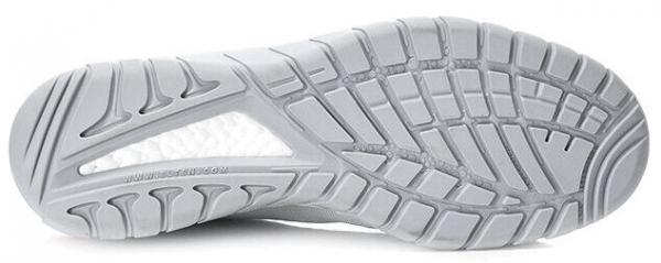 The image shows the underside of a gray sports shoe. The sole features a textured pattern with grooves and studs for better grip. The background is neutral and bright.