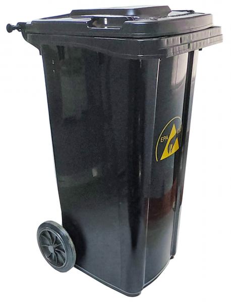 Der Abfallcontainer ist schwarz, hat zwei Räder zur Fortbewegung und einen abnehmbaren Deckel. Auf der Vorderseite befindet sich ein Warnschild mit einem gelben Dreieck.