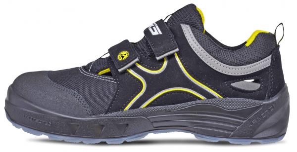 Der Schuh ist sportlich, schwarz mit gelben und grauen Akzenten. Er hat einen breiten, stabilen Absatz und einen Klettverschluss. Die Oberfläche ist aus einem robusten Material.