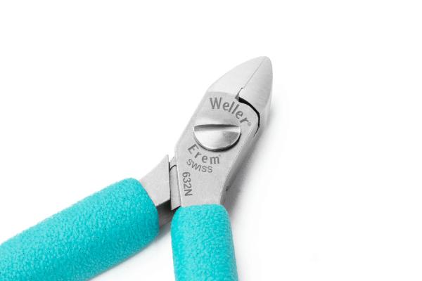 The image shows a pair of pliers with light blue, non-slip handles and a sharp, silver cutting edge. Manufacturer information is engraved on the metallic part.