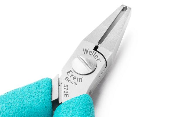 The image shows a pair of pliers with two long, pointed jaws. The handle is wrapped in a blue material. Brand inscriptions are visible on the pliers. The surface is metallically shiny.