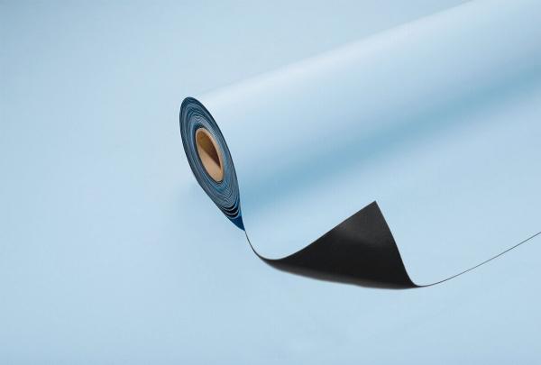 The image shows a roll of blue paper that is partially unrolled. The top side is light blue, the underside is a darker shade. The background is also light blue.