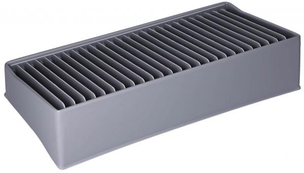 Das Bild zeigt eine rechteckige, graue Box mit vielen parallel angeordneten, horizontalen Rillen. Die Oberfläche ist glatt und die Kanten sind abgerundet, was einen modernen Look vermittelt.