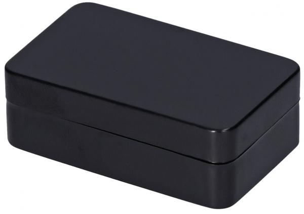 Das Bild zeigt eine rechteckige, schwarze Box mit glatten Oberflächen und abgerundeten Ecken. Sie hat einen Deckel, der auf die Unterseite passt. Die Box wirkt elegant und schlicht.