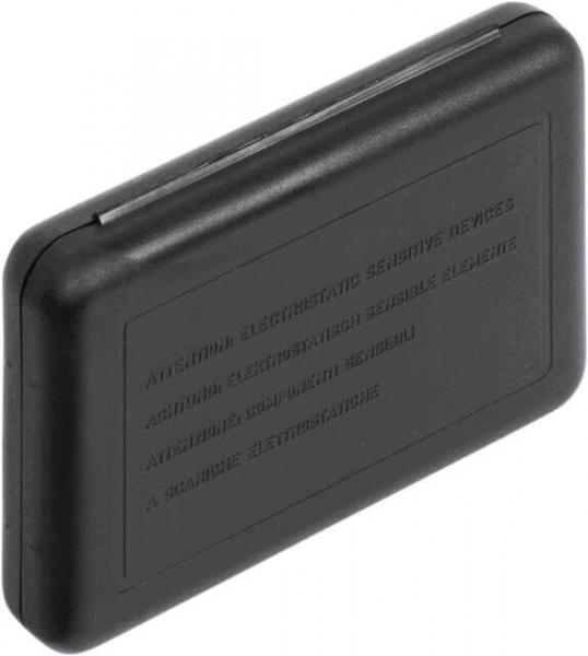 The image shows a small, rectangular, black casing with rounded edges. On the surface are various raised inscriptions that contain warnings.